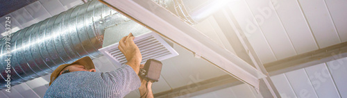 Quadro su tela Skilled technician installs ventilation system in industrial setting during the