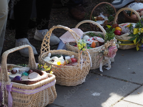 Close up of decorated wicker Easter baskets with eggs and cakes on the pavement