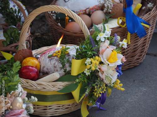 Close-up of a festive Easter basket decorated with yellow flowers and blue ribbons outdoors.