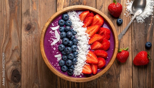 flat lay of a vibrant acai bowl with fresh strawberries, blueberries, 