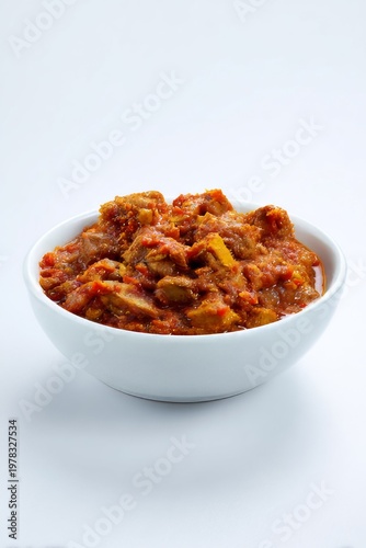 Hearty bowl of rich, spicy meat stew served in a clean white dish