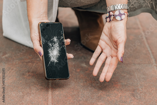 Фотография hands picking up a broken mobile phone