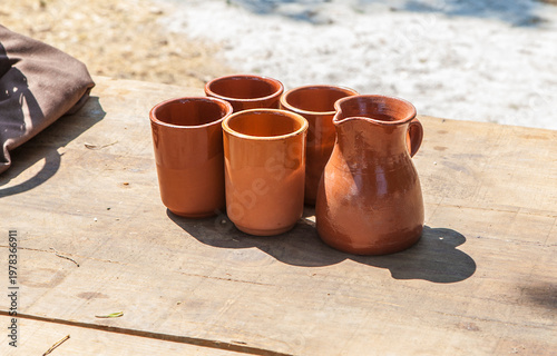 Clay glasses over wooden table