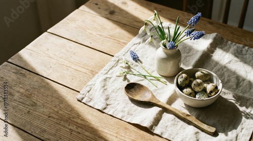 Quail eggs in bowl with spring flowers on linen cloth
