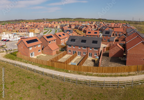 Affordable and energy efficient new build homes with eco friendly solar panels on a construction site in the UK