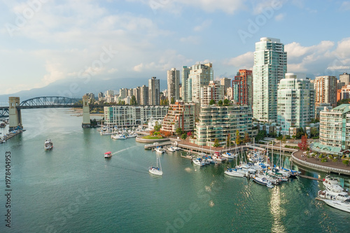 Burrard Street bridge crossing False Creek to the modern high-rise residential complexes and marina with The North Shore Mountains visible in the background, downtown Vancouver, Canada 