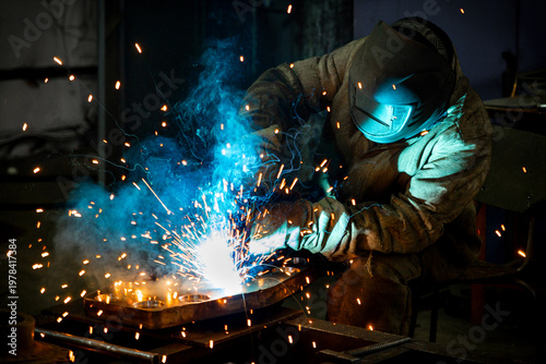 Canvas Print Welder works with a metal product. Beautiful sparks in the dark