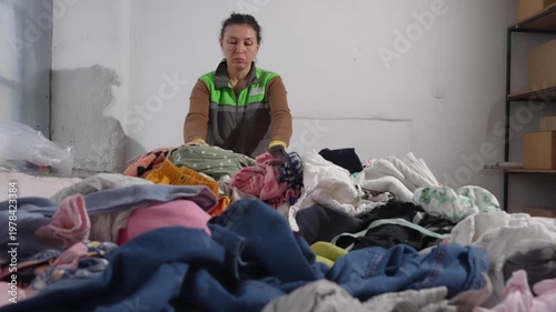 Woman sorting old clothes and shoes for recycling, reuse, and upcycling