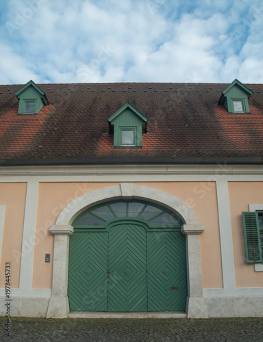Large green arched wooden carriage door of historic building in Hungary, traditional architecture.