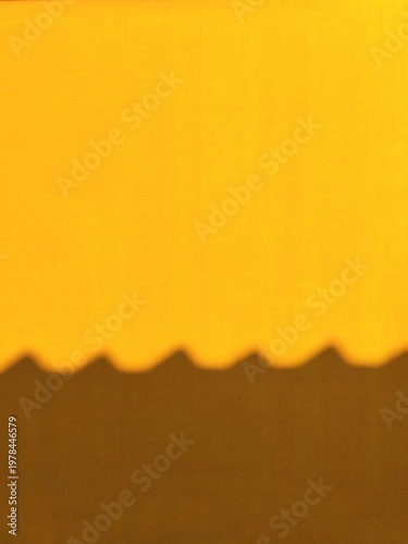 Minimalist Abstract Background of Sun Light and Geometric Roof Shadow on Bright Yellow Texture Wall Surface with Copy Space