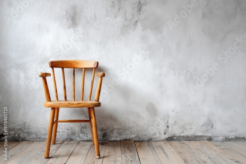 Wooden chair stands against a rustic textured wall and floor.