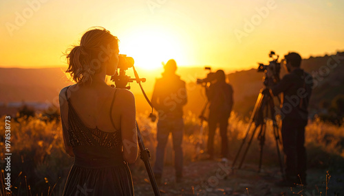 Film crew working at sunset, long shadows of cameraman and director, golden sky, behind the scenes scene