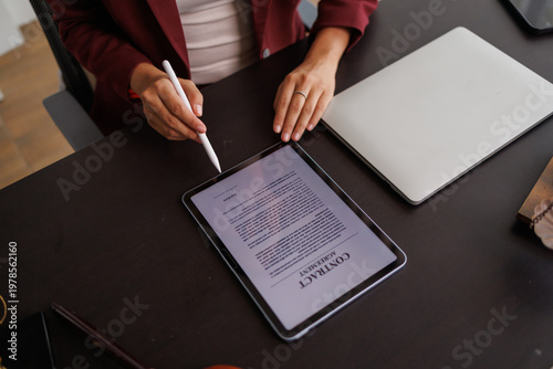 Businesswoman digitally signing contract on tablet with stylus