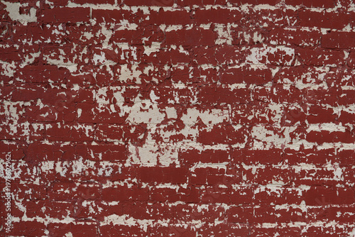 Red brick wall with cracked paint