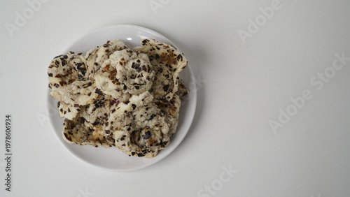 Photography Tike chips or keripik tike, a traditional snack from Indramayu, Indonesia, made from nutgrass tubers, served on a white plate