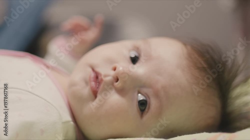 Close-up of an adorable baby's curious face lying down