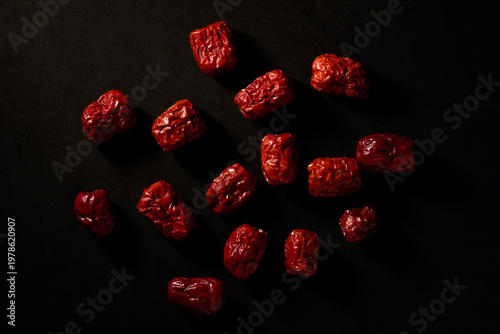Photography Dried red dates or Chinese jujube scattered on black background