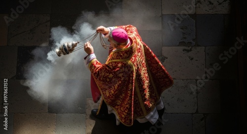 Overhead shot of a Catholic clergyman in red vestments performing a religious incensing ceremony with a smoking thurible, seen from above.