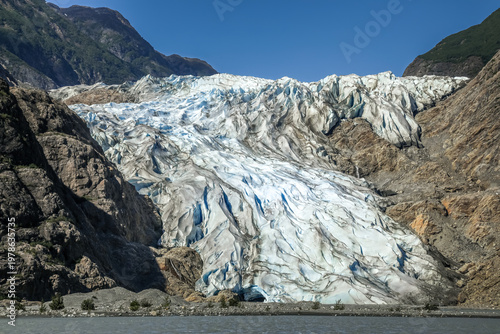 Massive Chilkat Glacier in Alaska towering above tranquil fjord waters
