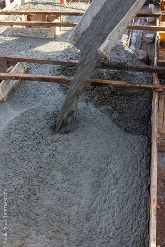 A migrant worker fills a septic tank with concrete on a summer day.