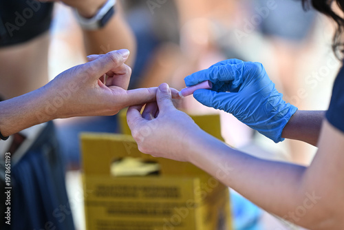 Foto Nurse pricking a patient's finger to perform a blood glucose test
