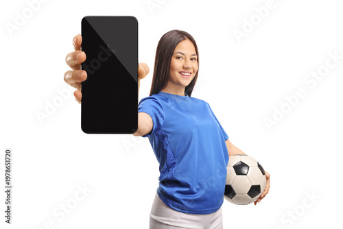 Female football player showing a blank smartphone screen and holding a ball