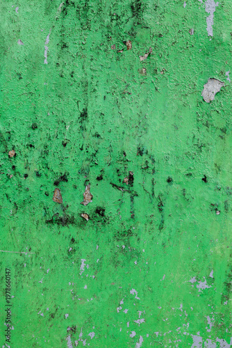 Highly detailed texture of old peeling green paint on a rough wall with weathered vintage character