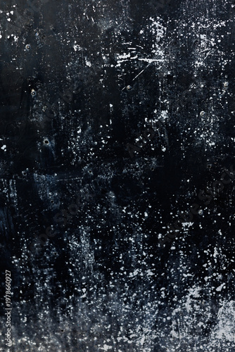 A weathered black industrial metal surface with distressed white paint splatters and heavy grunge texture