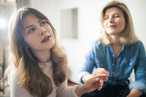 Young woman reaching hand to her mother figure for connection