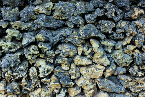 Foto High contrast texture of a rugged dark volcanic stone wall made of jagged natura