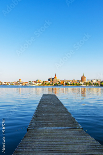 Blick über die Warnow und einem Steg auf die Hansestadt Rostock