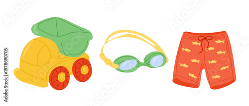 Colorful beach toys including a yellow dump truck, green swimming goggles, and red swim shorts with fish patterns arranged on a white background