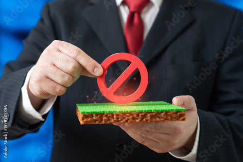 Konstfotografi An official holds a no entry sign over a plot of land