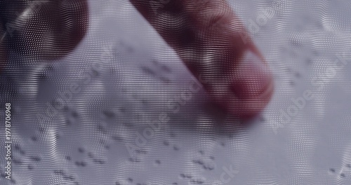 Pressing human fingertip on tabletop surface, showing fingernail, granular specks and halftone