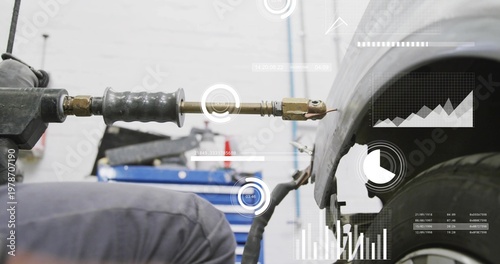 Canvas-taulu Kneeling tech wearing coveralls fixing fender in bay, holding stud welder with b