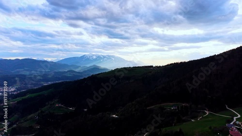 Drone flyover hills with houses and peaks
