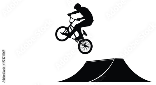 Silhouette of a person riding a bicycle on a ramp