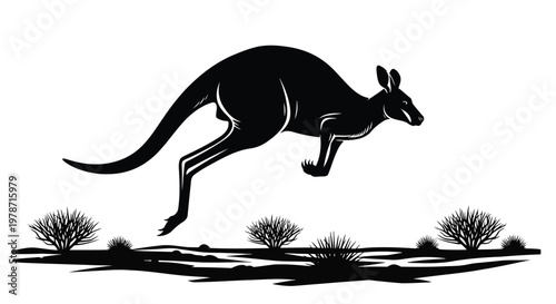 Black silhouette of a kangaroo jumping over desert plants