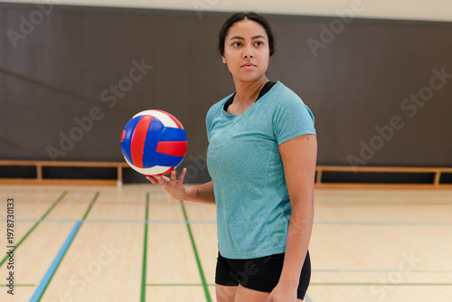 Foto Female player holding volleyball and looking ahead, showing shot path over court