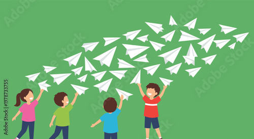 Group of diverse children throwing many white paper airplanes into the air against a solid green background for fun play.