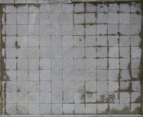 Grimy tiled floor with mildew stains in outdoor setting