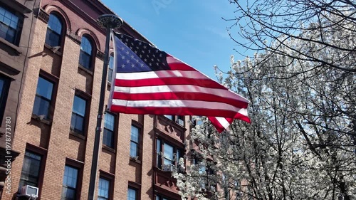 American flag flapping in front of Brooklyn brownstone houses