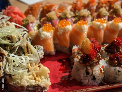 Assorted fresh sushi rolls served elegantly on a bright red ceramic plate for dinner party
