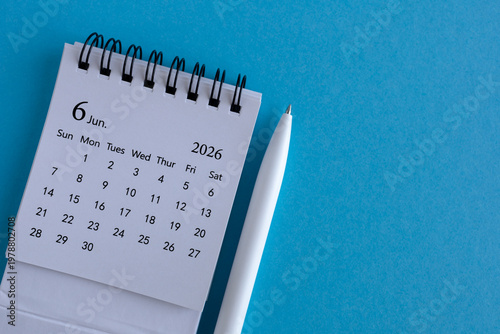 Desk calendar for June 2026 on a blue background with space for notes.