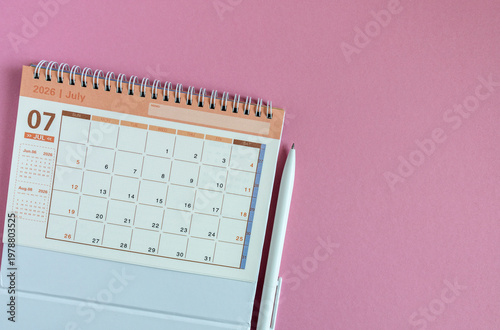 Desk calendar for July 2026 on a pink background with copy space.