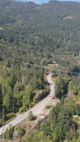Aerial View of Cars Driving on a Winding Mountain Road Through Lush Forests in British Columbia, Canada