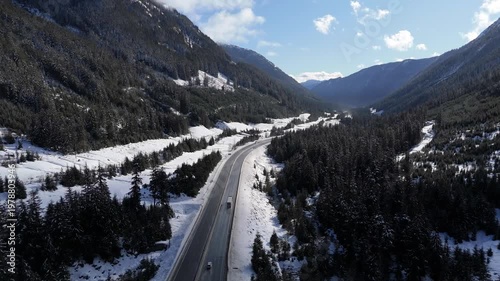 Aerial View of a Winter Highway Winding Through Snowy Mountain Forest in British Columbia, Canada