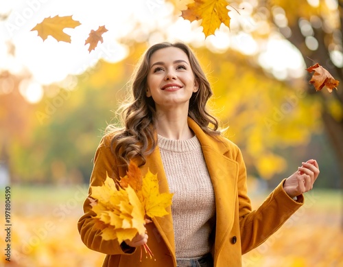 A young woman joyfully looks up as falling golden leaves drift down in a park, holding a bunch