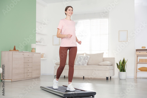 Quadro su tela Sporty woman training on treadmill at home, low angle view