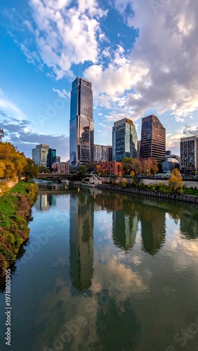 A vibrant shot showcasing a cityscape with modern skyscrapers, reflecting on calm river waters under a cloudy sky
